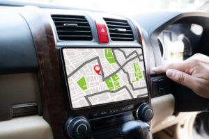 Finger zeigt auf Navigationskarte im Autodisplay